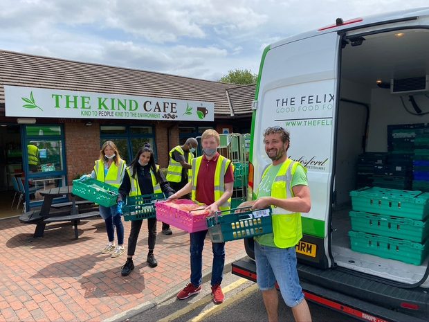 Volunteers unloading crates of surplus food from a partner van at The Kind Cafe